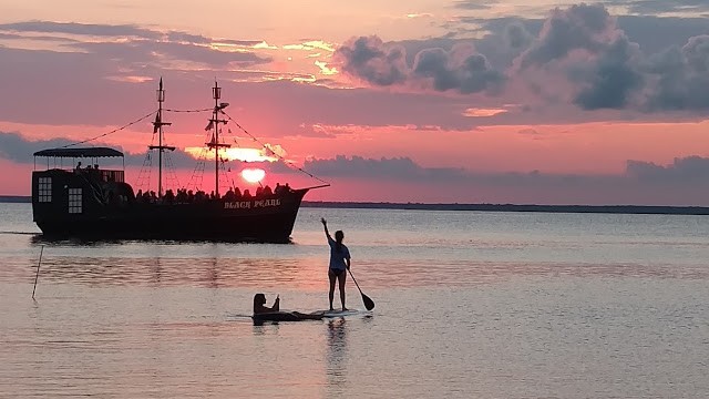 The Black Pearl and Paddleboarders at sunset